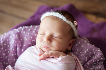 Cute newborn baby sleeping in a wooden basket