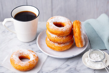 Donuts on a plate with cup of coffee. Grey background. Close up.