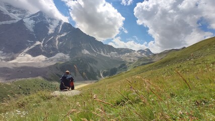 Fototapeta na wymiar hiker in the Caucasus mountains. man sit on the stone on Cheget mountain