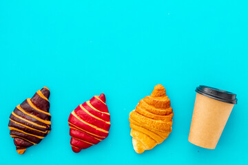 Coffee and croissants on blue table top view