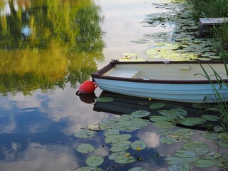 Moored white colour wooden fishing boat in a canal of the lake Balaton, Hungary in summer