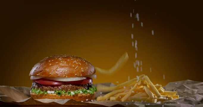 French fries fall next to the burger. Burger with falling fries.