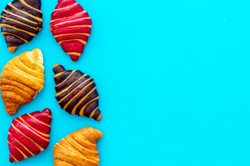 Set of croissants - chocolate, berry, classic - on blue table top view
