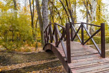 Wooden bridge in the autumn park.