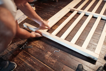 Carpenter hobbyist assembling wooden boards at home / garage.