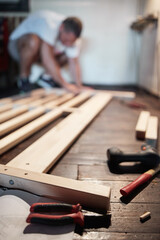 Carpenter hobbyist assembling wooden boards at home / garage.