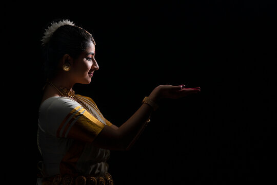 Mohiniattam artist looking at her hands with a smile
