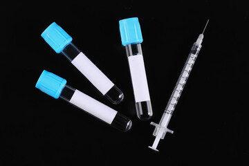 Medical test tubes and syringe isolated on black background