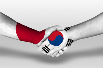 Handshake between south korea and japan flags painted on hands, illustration with clipping path.
