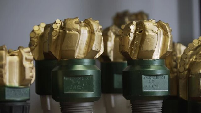Brand new PDC Polycrystalline Diamond Compact drilling bit. Macro shot of drill bits on shelving in stock. Oil drilling equipment for drilling rig operation on oil platform in oil and gas industry.