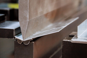 Bending sheet metal with a hydraulic machine at the factory.