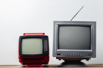 Two retro old-fashioned portable tvs on a white background. Retro media