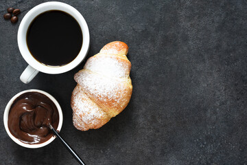 Croissants with espresso on a black concrete background. view from above.