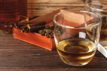 Red wooden box with rolled cigars on wooden table close up