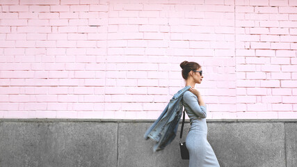 Street Style Shoot Woman on Pink Wall. Swag Girl Wearing Jeans Jacket, grey Dress, Sunglass....