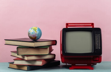 Retro tv and stack of books with globe on pink background. TV distance learning.