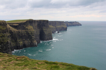 Cliffs of Moher with cloudy skies and vegetation in Ireland