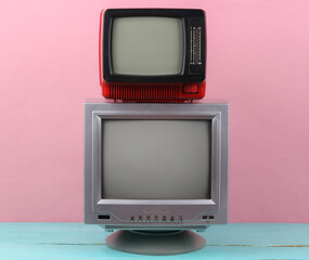 Two retro old-fashioned portable tvs on pink background. Retro media