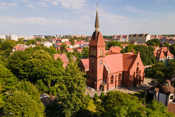 Drone view of saint Adalbert's church between green trees in sunny day