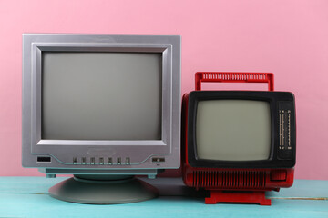 Two retro old-fashioned portable tvs on pink background. Retro media