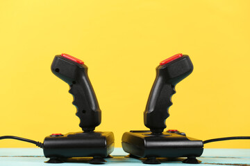Retrogaming. Video game competition. Retro joysticks on  yellow background. Attributes 80s