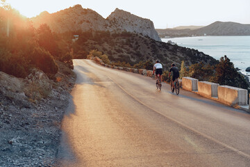 Two professional male cyclists riding their racing bicycles in the morning together
