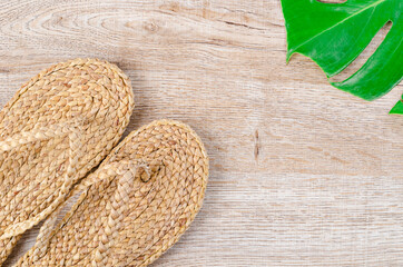 Flip flop made from Water hyacinth or Floating water hyacinthwith green leaf on wooden background.