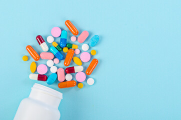 Medical pills and tablets spilling out of a drug bottle.