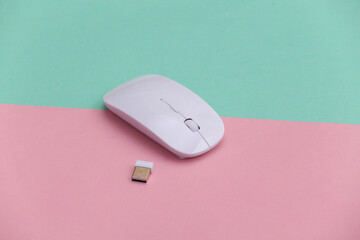 White modern wireless pc mouse on pink blue background.