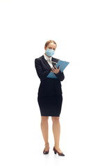 Working in face mask. Young woman, accountant, finance analyst or booker in office suit isolated on white studio background. Caucasian woman, office worker. Finance, economy, professional occupation.