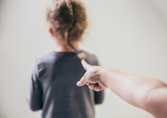Child bully pointing finger at blurred unrecognizable victim and talking behind back. Bullying...