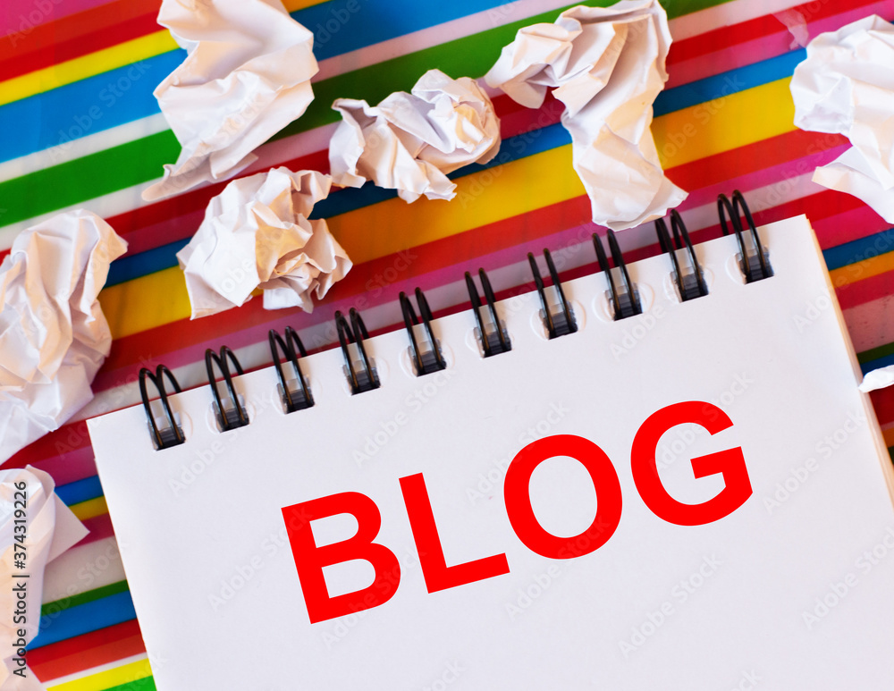 Poster the word blog is written in red in a white notebook on a bright striped multi-colored background nea
