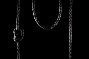 Hanging black rope on a black background