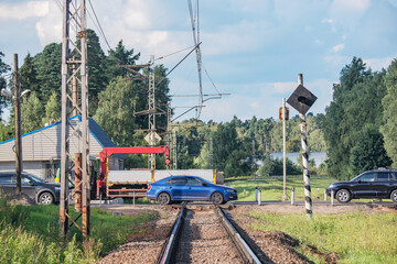 Cars cross the railroad track.