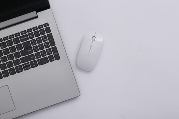Laptop with pc mouse on white background. Online workspace. Remote work. Studio shot. Top view. Flat lay