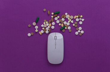 Pc mouse with pills on purple background. Top view. Flat lay