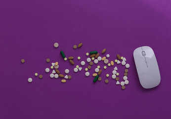 Pc mouse with pills on purple background. Top view. Flat lay