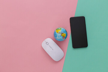 Global network. Pc mouse, smartphone, globe on pink blue background. Studio shot. Top view. Flat lay