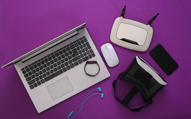 Modern youth gadgets and devices on purple background. Top view. Flat lay