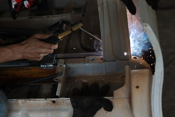 Worker,welding in a car factory with sparks, manufacturing, industry