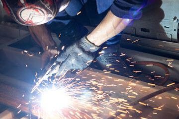 Worker,welding in a car factory with sparks, manufacturing, industry