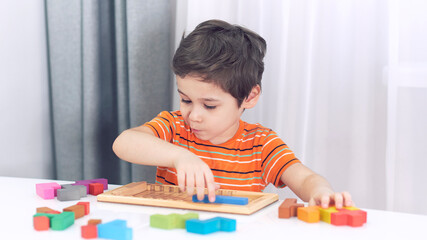 toddler boy playing indoors with educational toy.