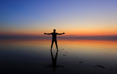 Silhouettes of a man on sunset background