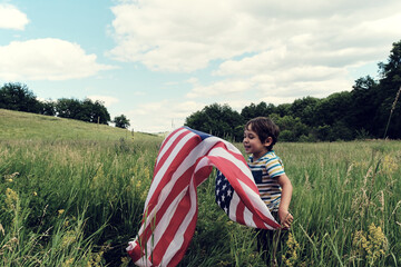 Patriotic holiday.Young boy with American flag.USA celebrate 4th of July.