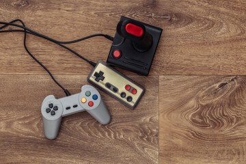 Retro joystick and gamepad on a wooden floor. Top view