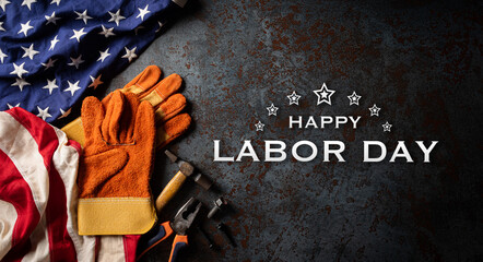 Happy Labor day concept. American flag with different construction tools on dark stone background,...