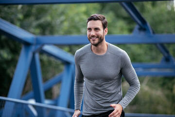 Young man jogging in the city. Happy athlete training outdoors.