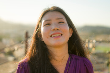 young happy and beautiful Asian Korean woman outdoors at viewpoint balcony enjoying sunset view of Spain town during Europe holiday travel feeling free