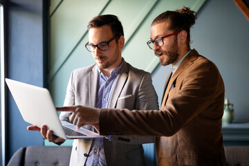 Business colleagues laughing while looking at the laptop