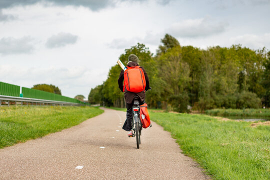 A lonely biker with a backpack near the A44 highway in the south-Holland village of Sassenheim in the Netherlands.